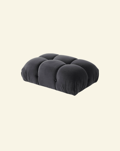 Camaleonda ottoman in black velvet replica with button-tufted detailing, shown in a high-resolution studio setting on a beige background.
