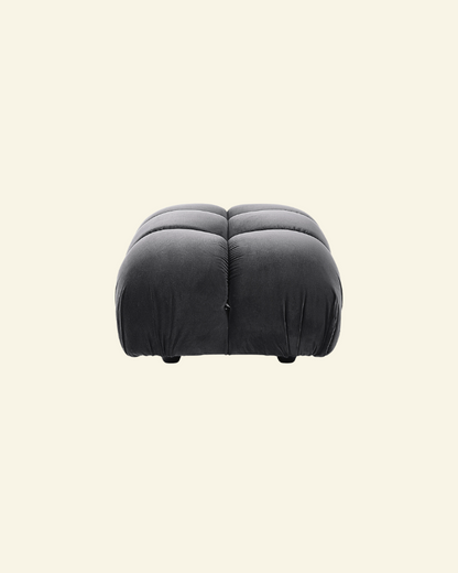 Camaleonda ottoman in black velvet replica with button-tufted detailing, shown in a high-resolution studio setting on a beige background.