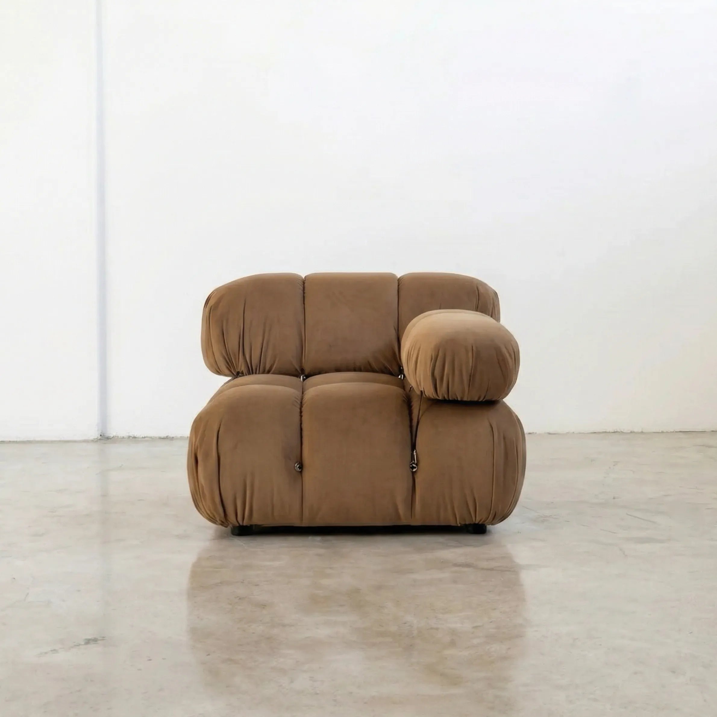 Camaleonda dupe section with armrest in brown velvet on a beige background on a white floor with a white wall background