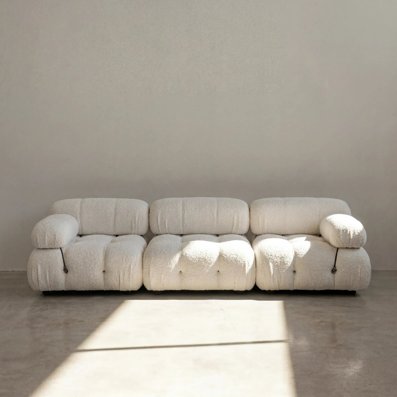 Modern modular camaleonda sofa dupe in white boucle against a plain wall