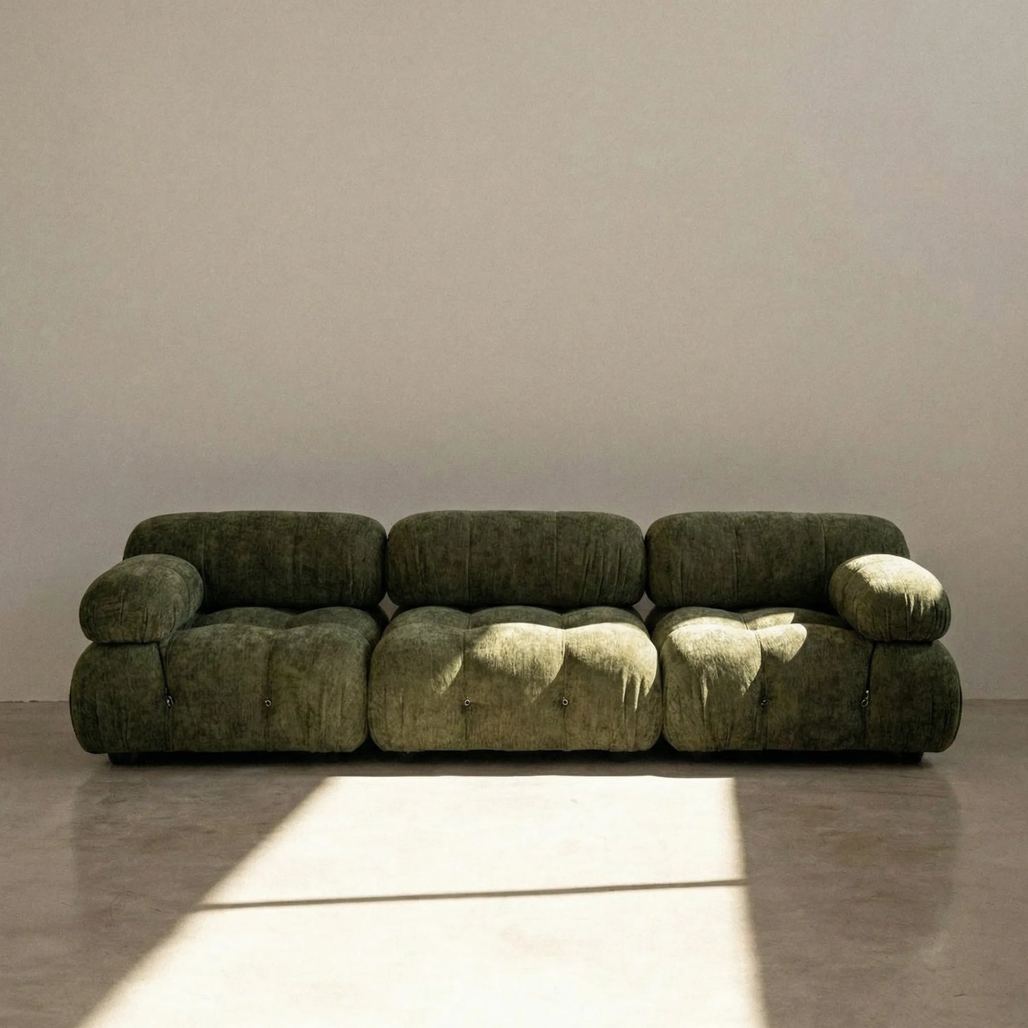 Camaleonda dupe sofa in green chenille against a plain wall