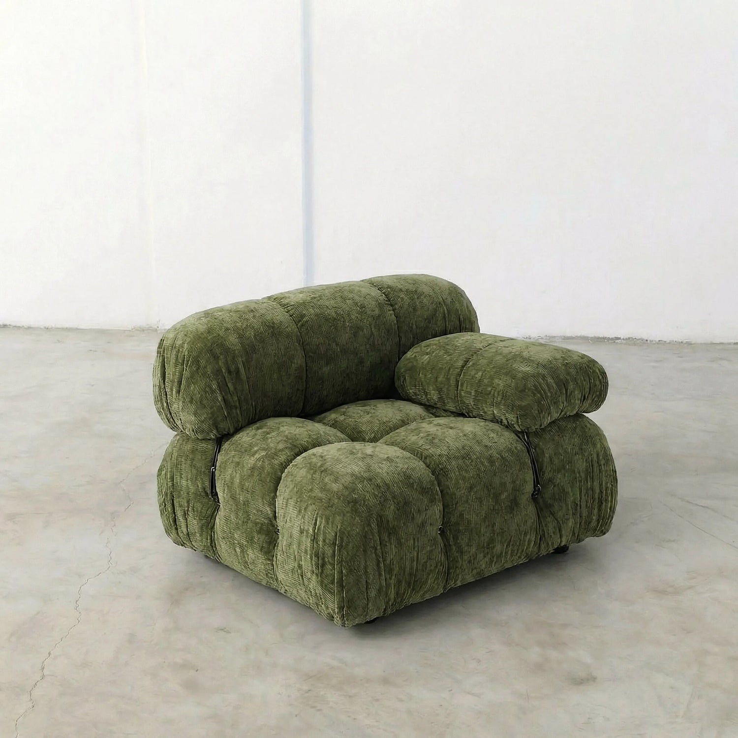 Camaleonda dupe section with armrest in green chenille on a light gray floor with a white wall background