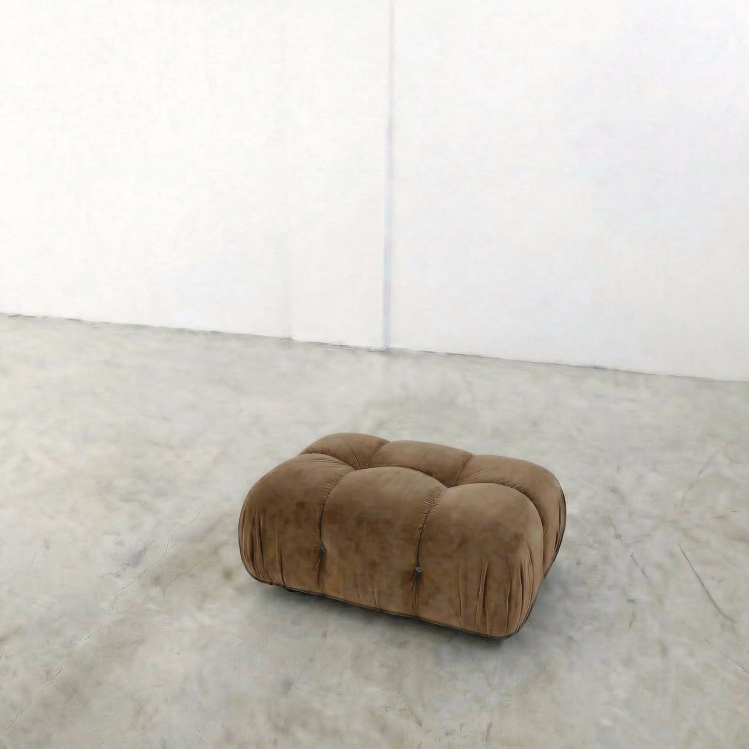brown camaleonda ottoman alternative on a concrete floor with white walls