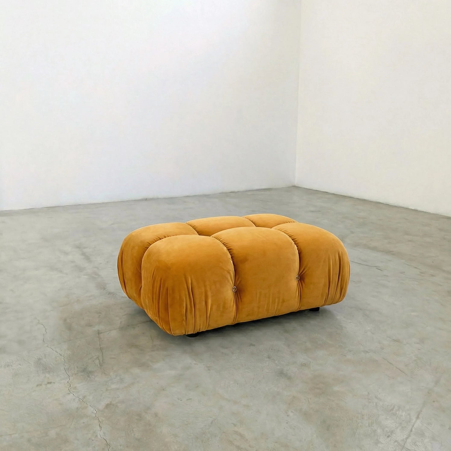 mustard camaleonda ottoman alternative on a concrete floor with white walls