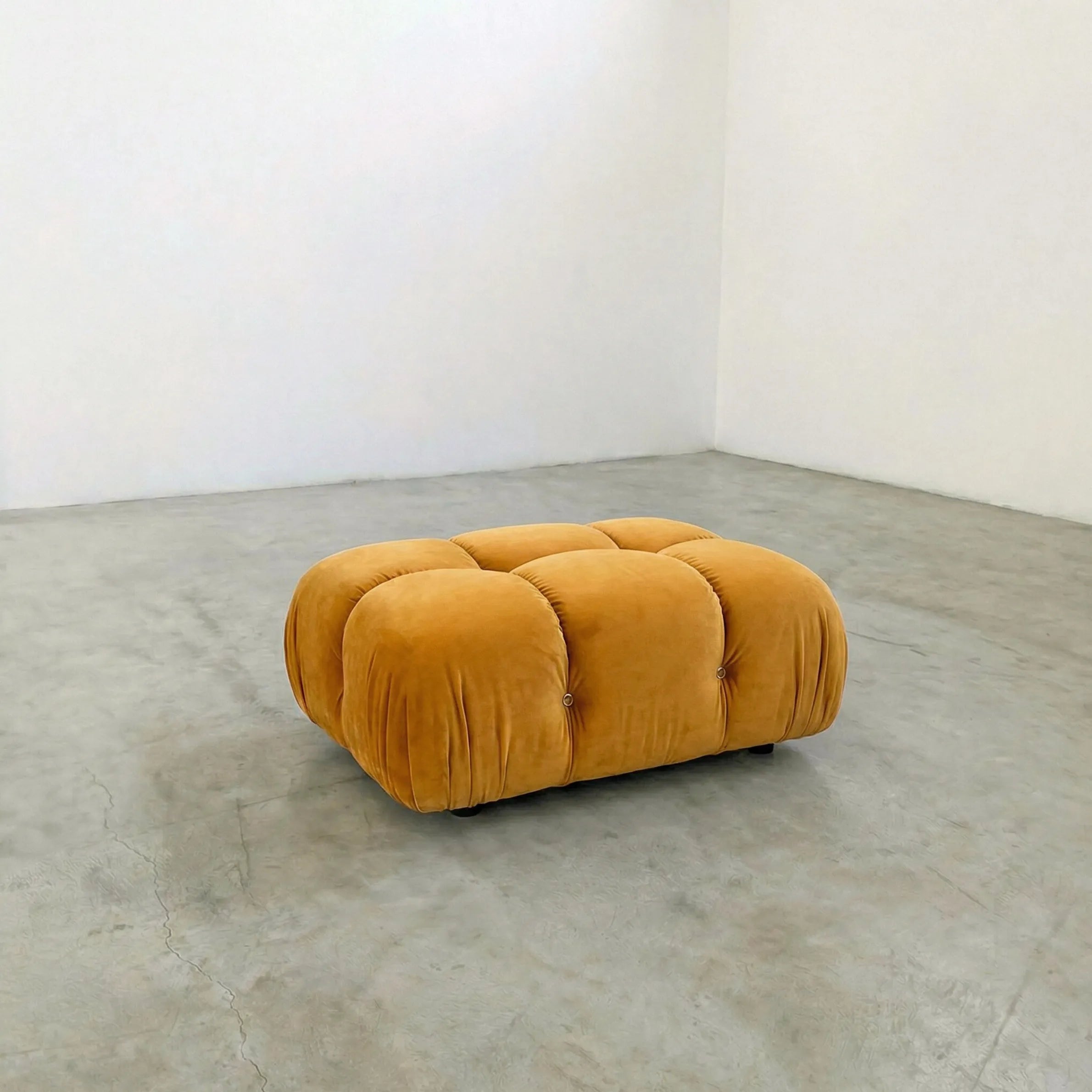 mustard camaleonda ottoman alternative on a concrete floor with white walls