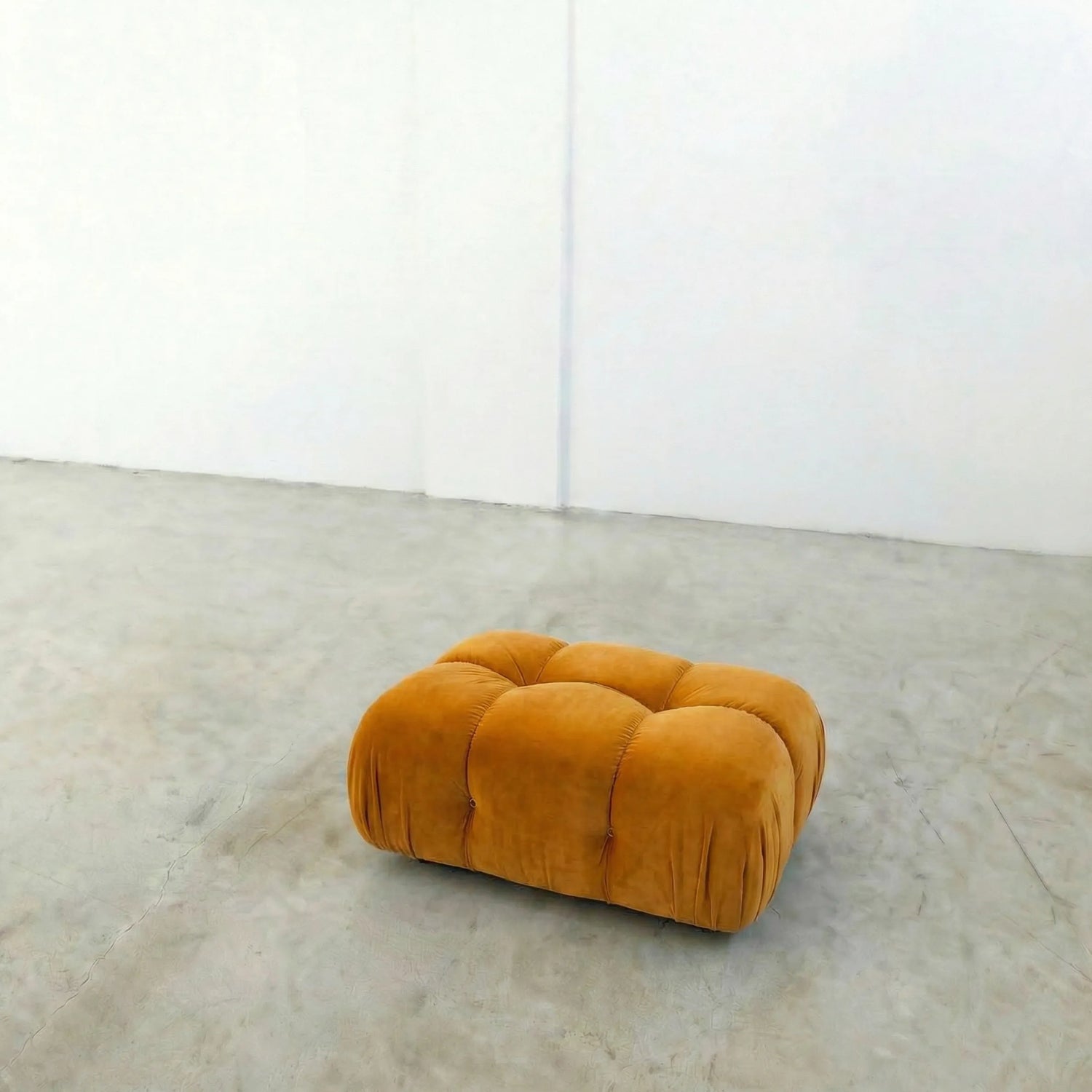 mustard camaleonda ottoman alternative on a concrete floor with white walls