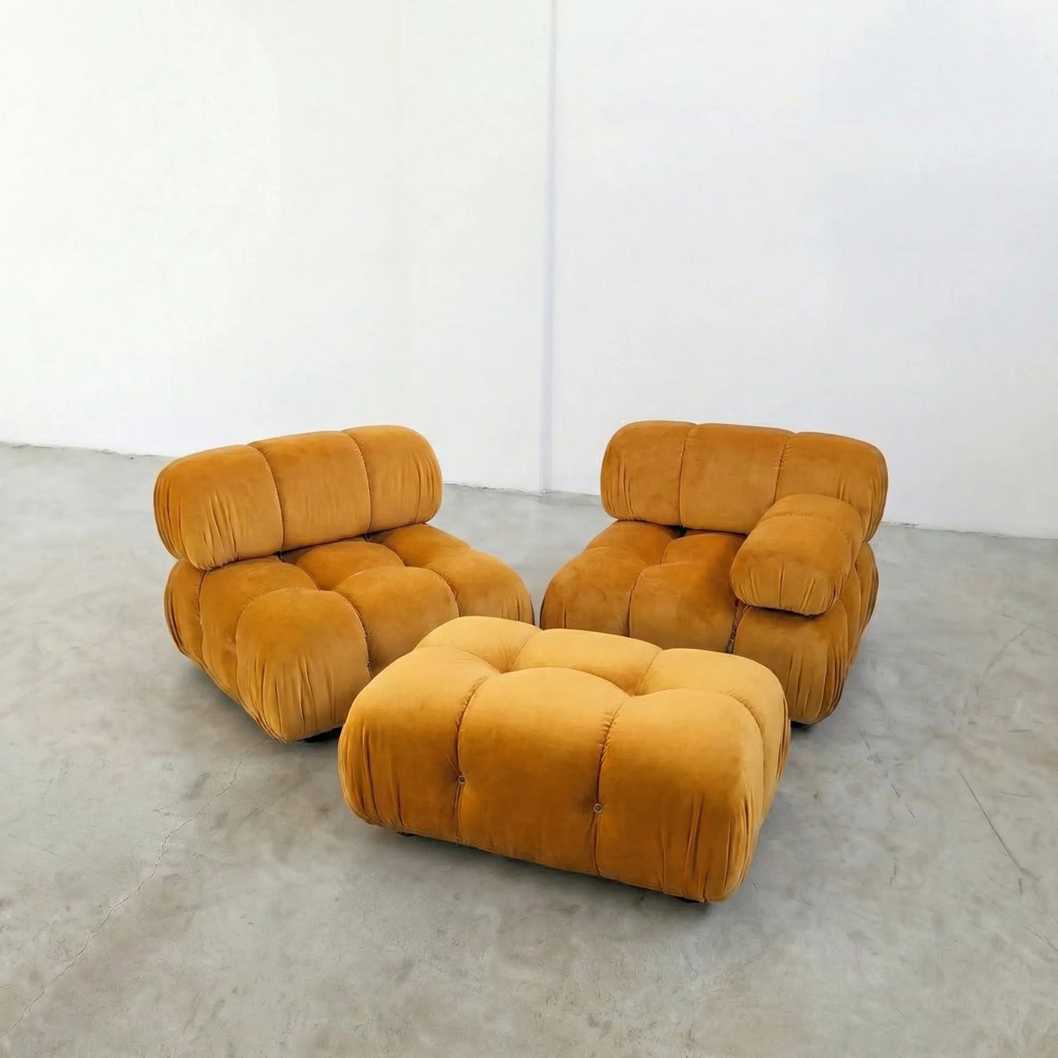 mustard camaleonda ottoman and armchairs alternative on a concrete floor with white walls