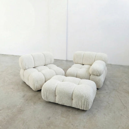 white boucle camaleonda ottoman and armchairs alternative on a concrete floor with white walls