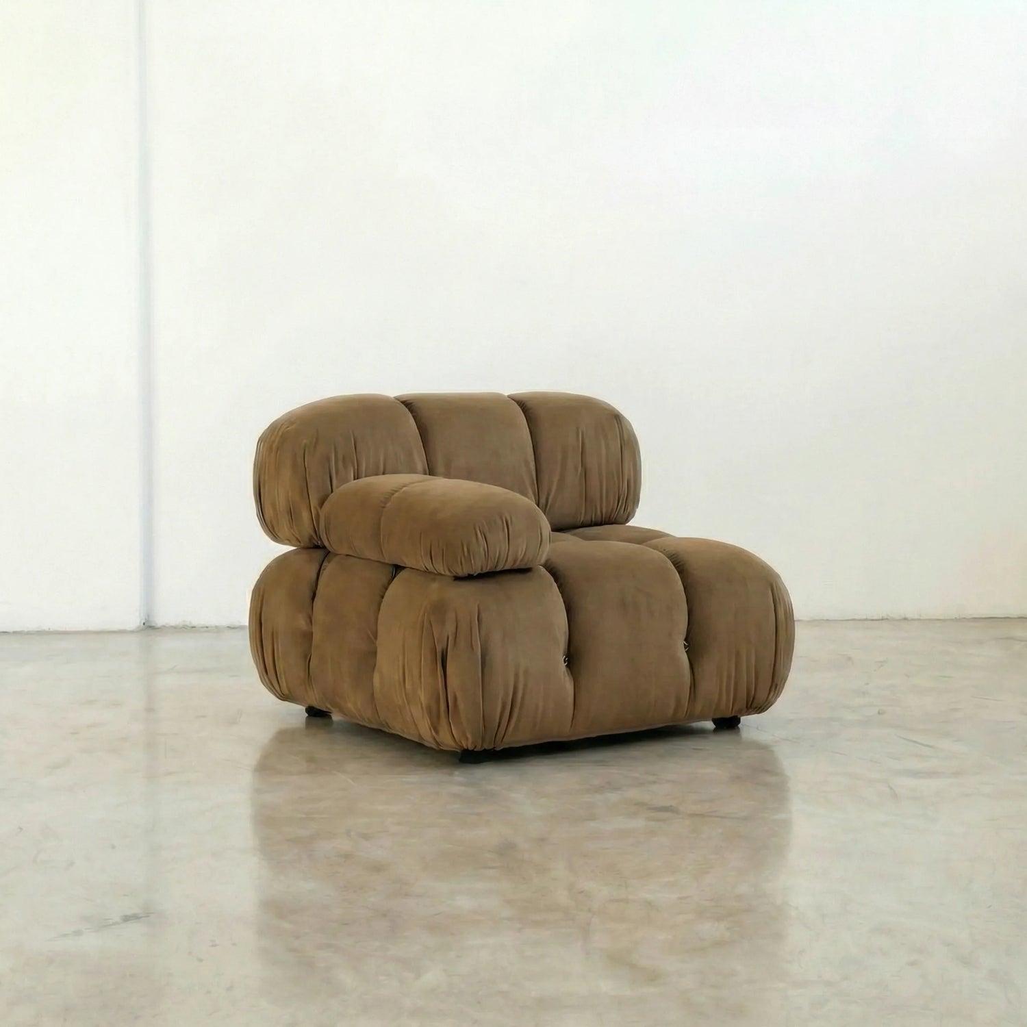 Camaleonda modular sofa section alternative with right armrest in brown velvet  in a minimalistic room with white walls and a concrete floor.