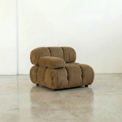 Camaleonda modular sofa section alternative with right armrest in brown velvet  in a minimalistic room with white walls and a concrete floor.