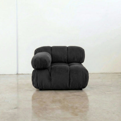 Camaleonda modular sofa section alternative with right armrest in dark grey velvet on a reflective floor with a white wall background