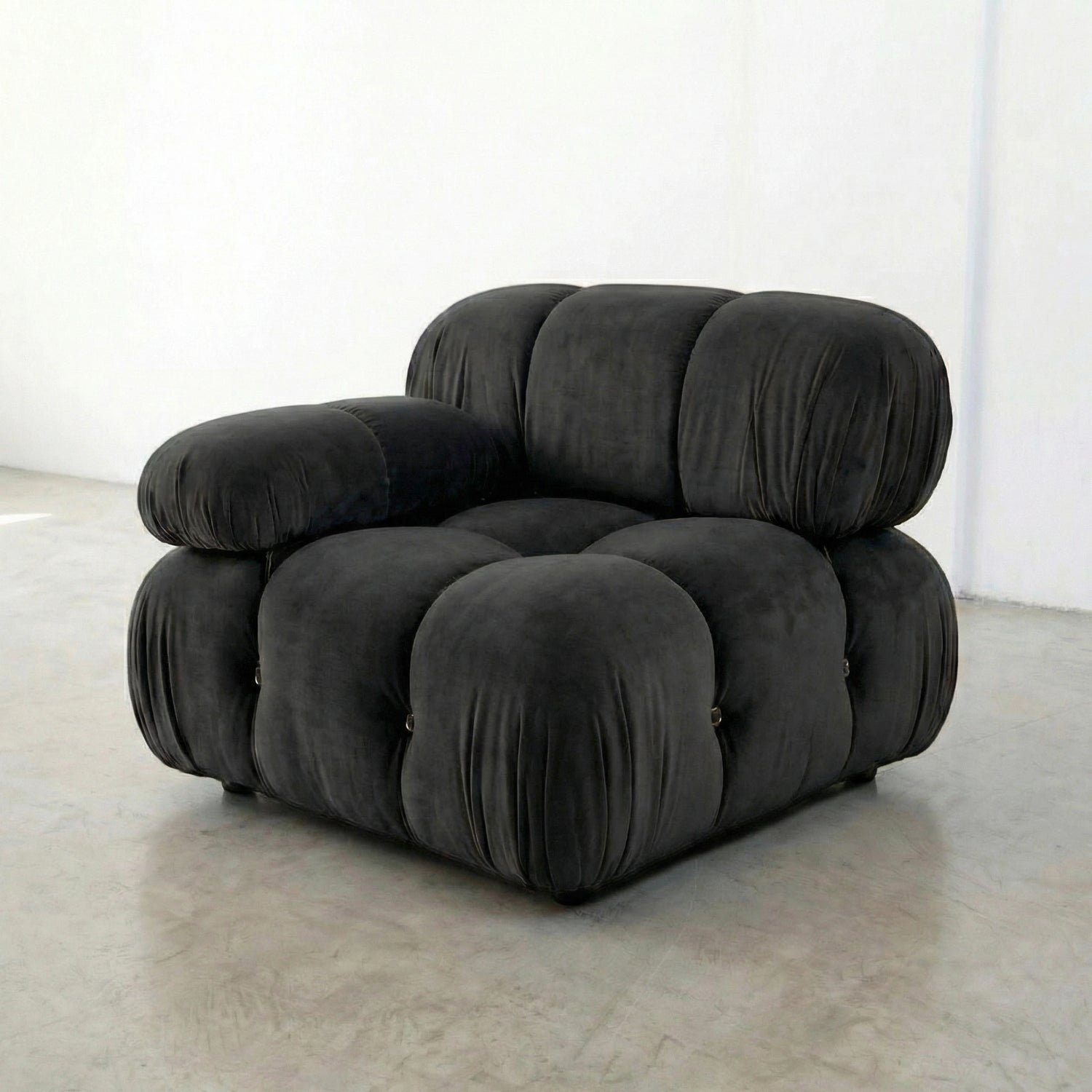 Dark Grey camaleonda armchair dupe on a white floor with a white wall background