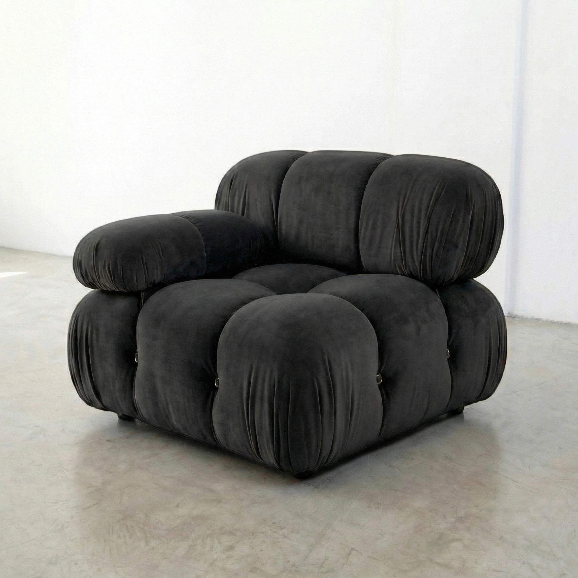 Dark Grey camaleonda armchair dupe on a white floor with a white wall background