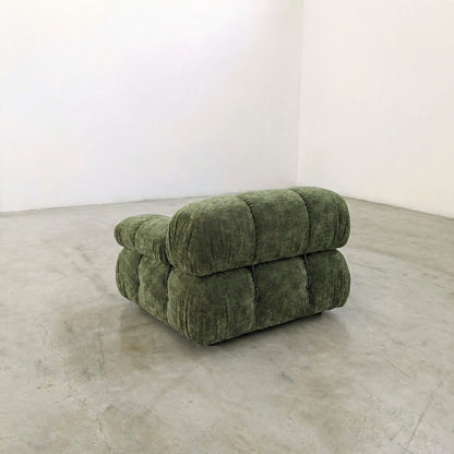 Camaleonda modular sofa section alternative with right armrest in green chenille in a minimalistic room with white walls and concrete floor.
