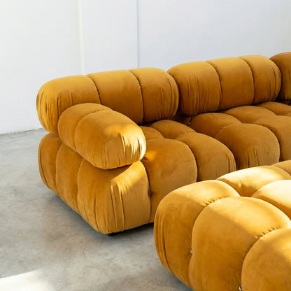 Camaleonda modular sofa section alternative with right armrest in mustard yellow velvet with a modern design on a light gray floor.