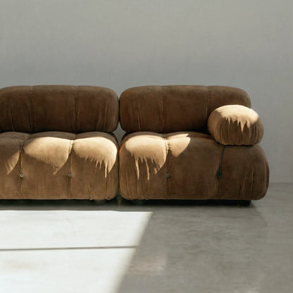 Camaleonda modular sofa dupe in brown velvet with tufted upholstery in a minimalistic room with concrete floor and white walls