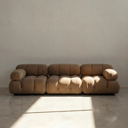 Camaleonda 3 seater modular sofa dupe in brown velvet with tufted upholstery in a minimalistic room with concrete floor and white walls