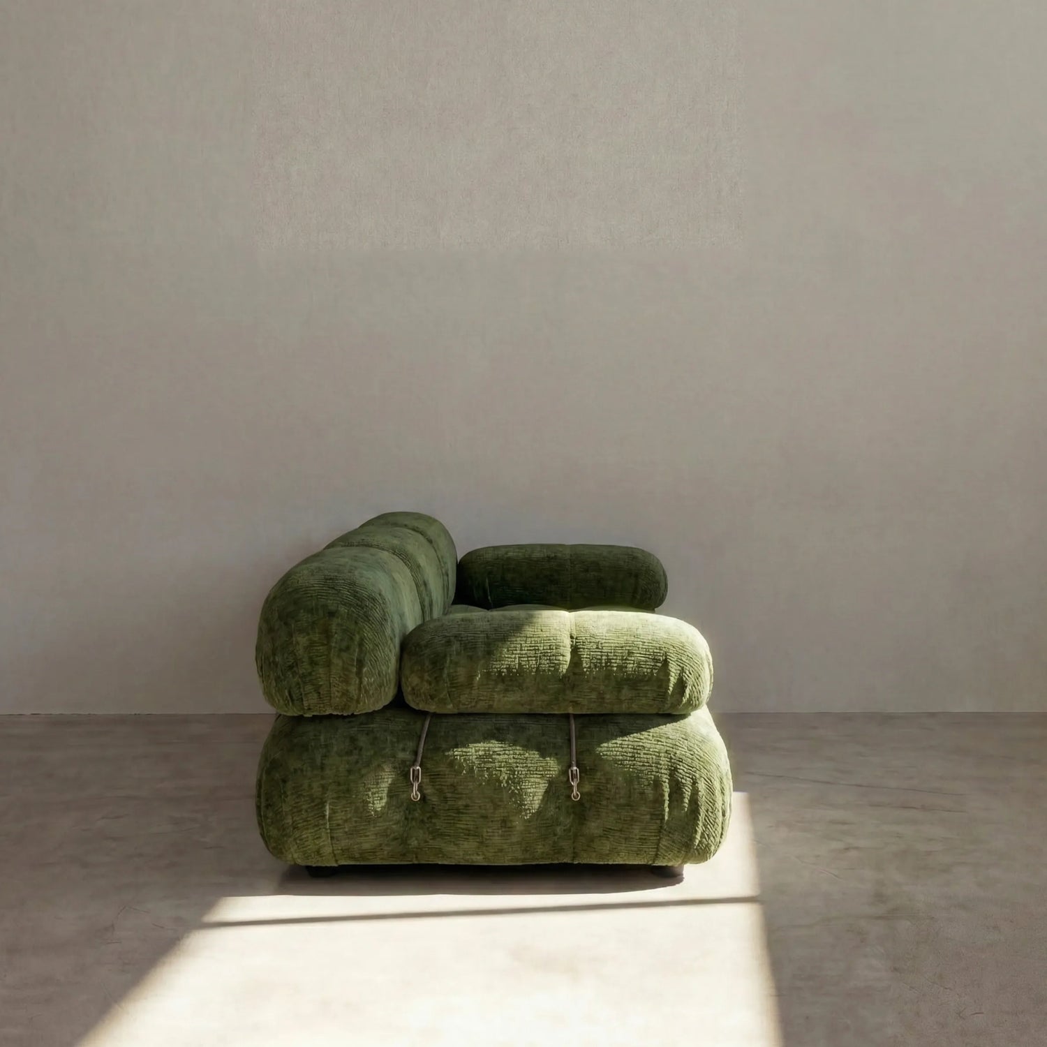 Camaleonda 3 seater modular sofa dupe in green chenille with tufted upholstery in a minimalistic room with concrete floor and white walls