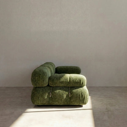 Camaleonda 3 seater modular sofa dupe in green chenille with tufted upholstery in a minimalistic room with concrete floor and white walls