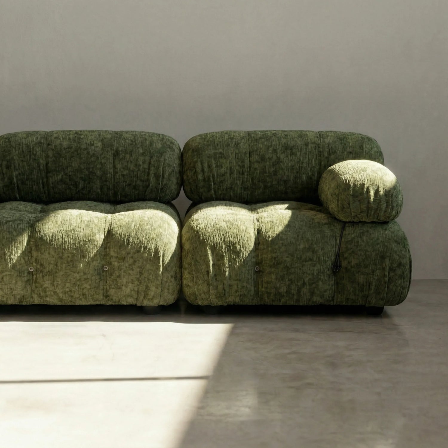 Camaleonda modular sofa dupe in green chenille with tufted upholstery in a minimalistic room with concrete floor and white walls