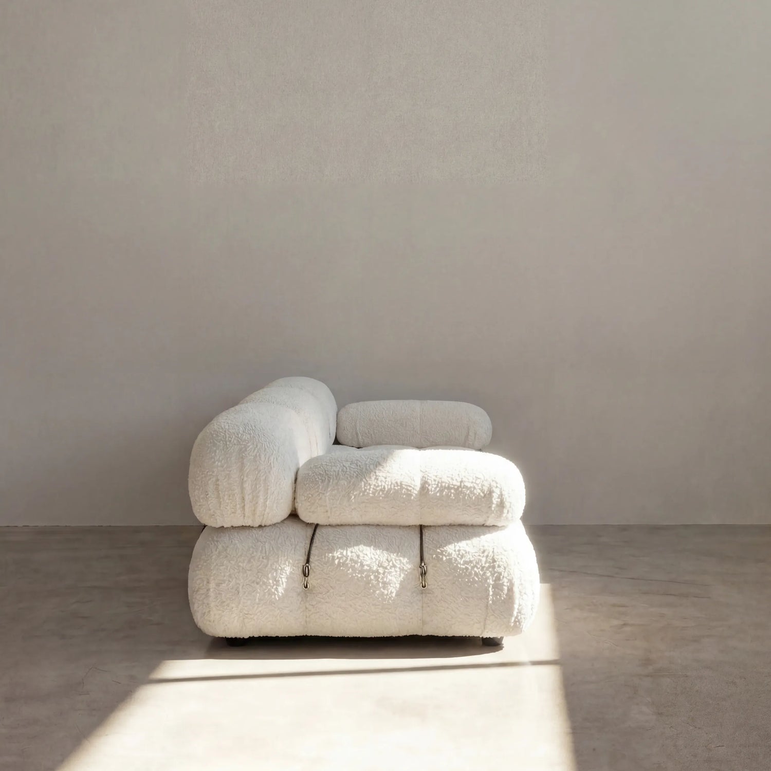 Camaleonda 3 seater modular sofa dupe in white bouclé with tufted upholstery in a minimalistic room with concrete floor and white walls