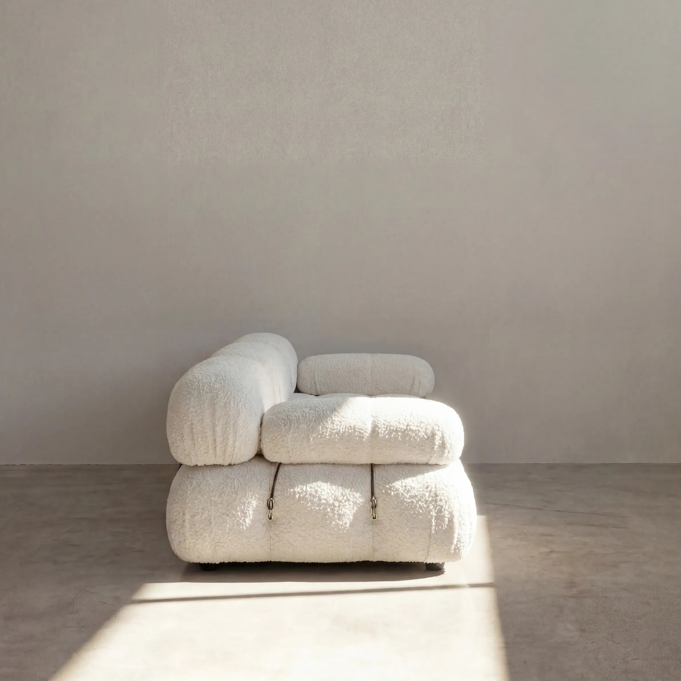 Camaleonda 3 seater modular sofa dupe in white bouclé with tufted upholstery in a minimalistic room with concrete floor and white walls