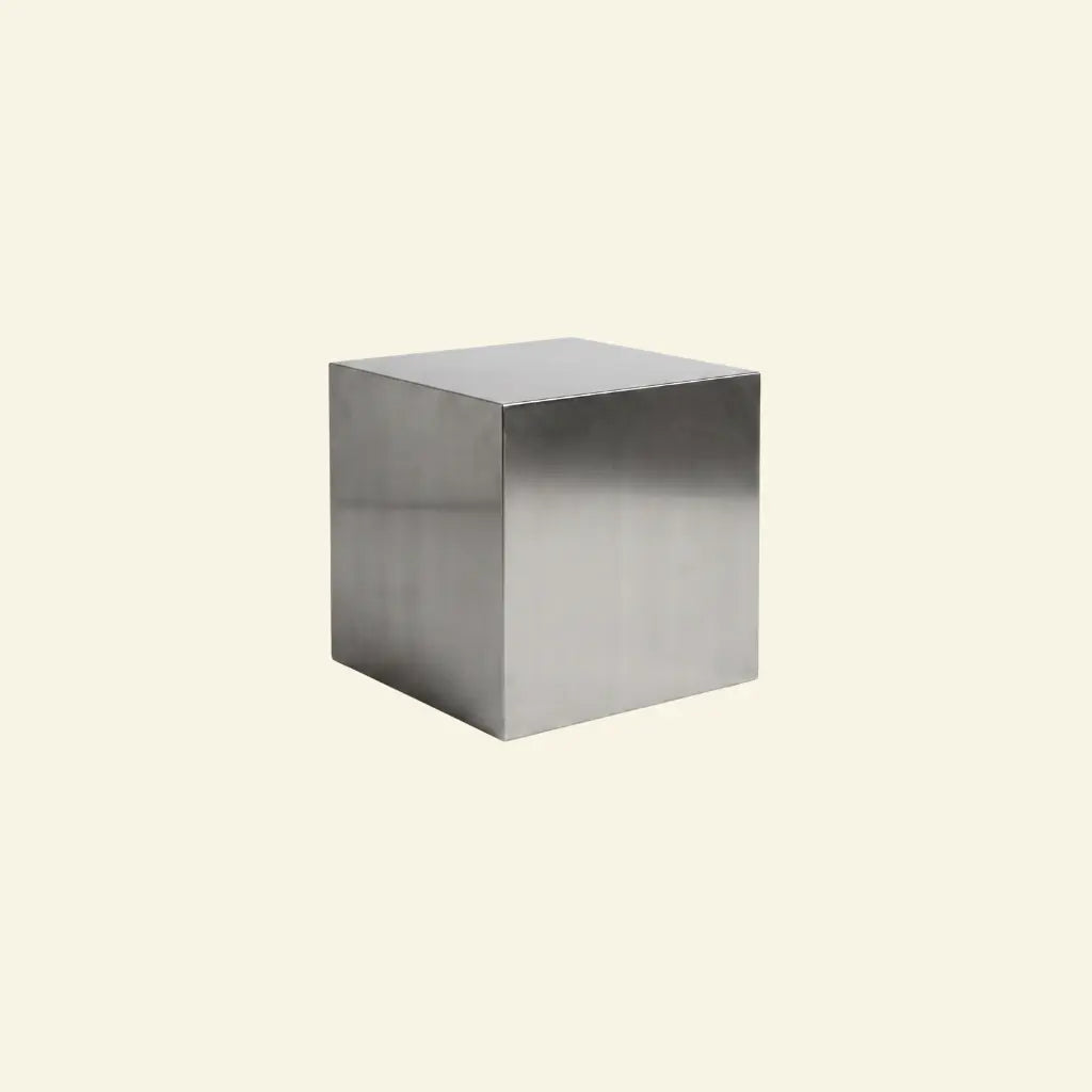 Metallic steel cube table on a beige background