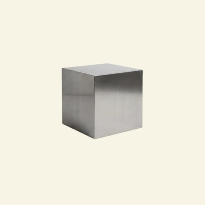 Metallic steel cube table on a beige background