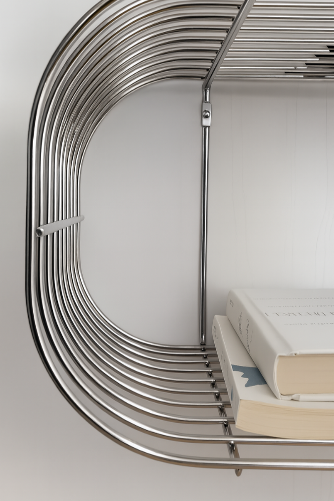Metallic chrome floating wire circular shelf with books on a white background