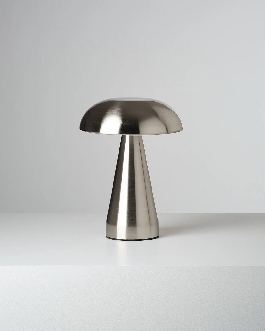 Metallic chrome mushroom table lamp on a white background