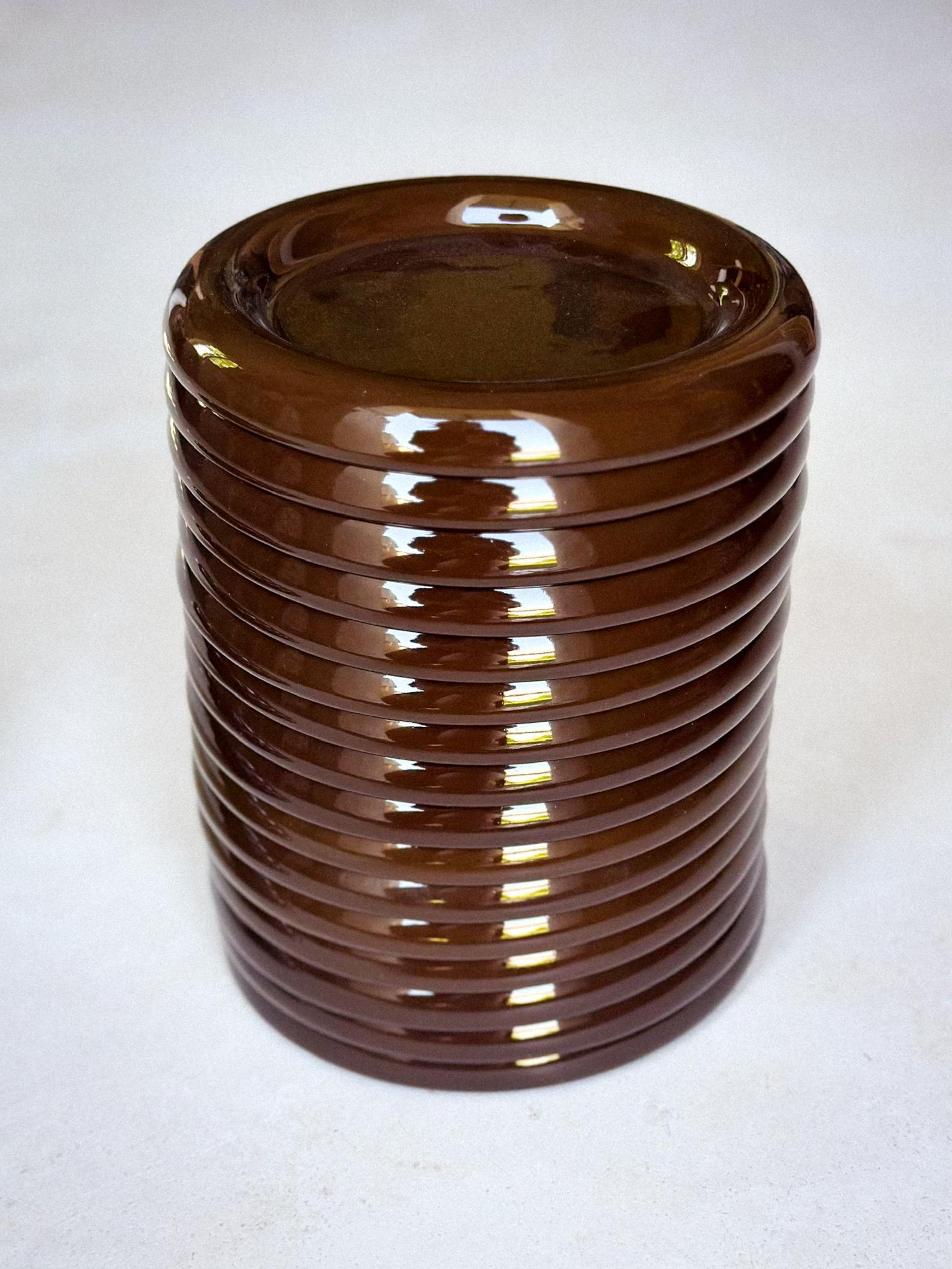 Stack of brown chunky ceramic plates on a white background
