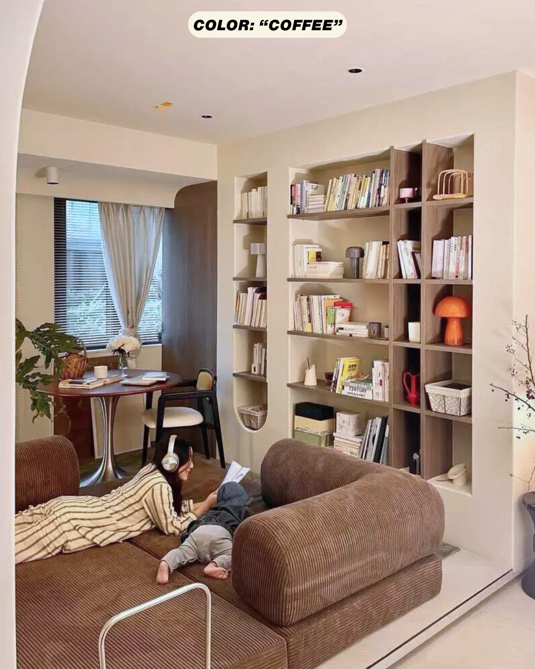 Living room with brown coffee colored teddy sofa dupe, bookshelves, and a child playing on the floor.