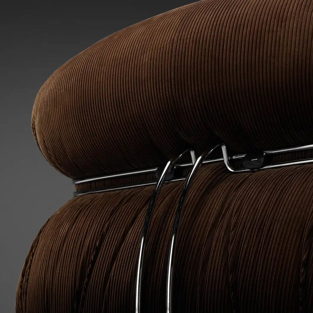 Close-up of designer lounge chair soriana upholstery texture in brown corduroy and chrome detail in contemporary home setting