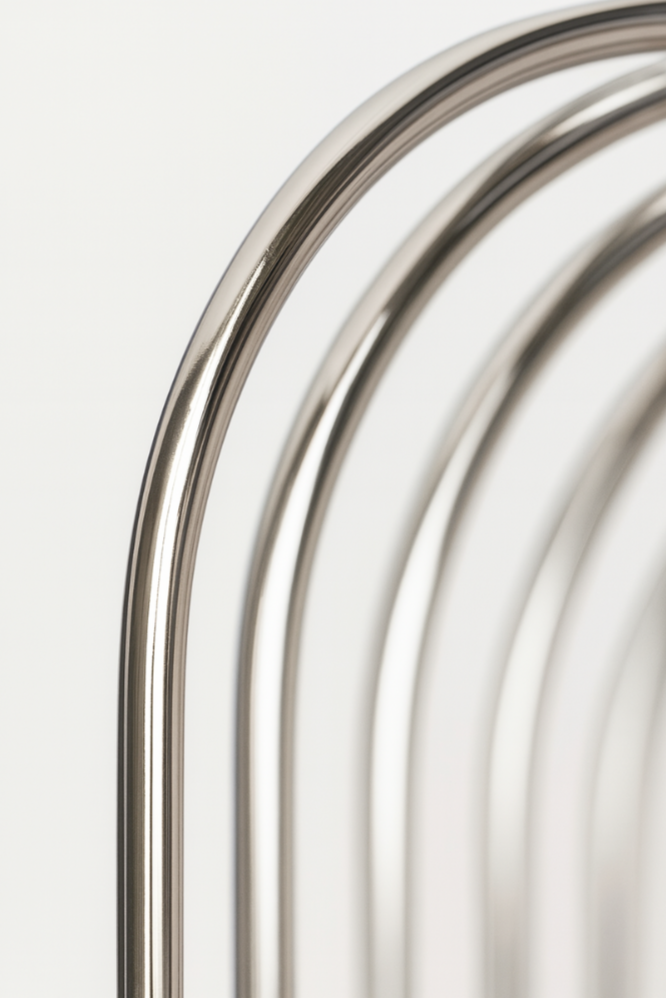 Close-up angled view of floating chrome wire wall shelf with shiny stainless steel finish