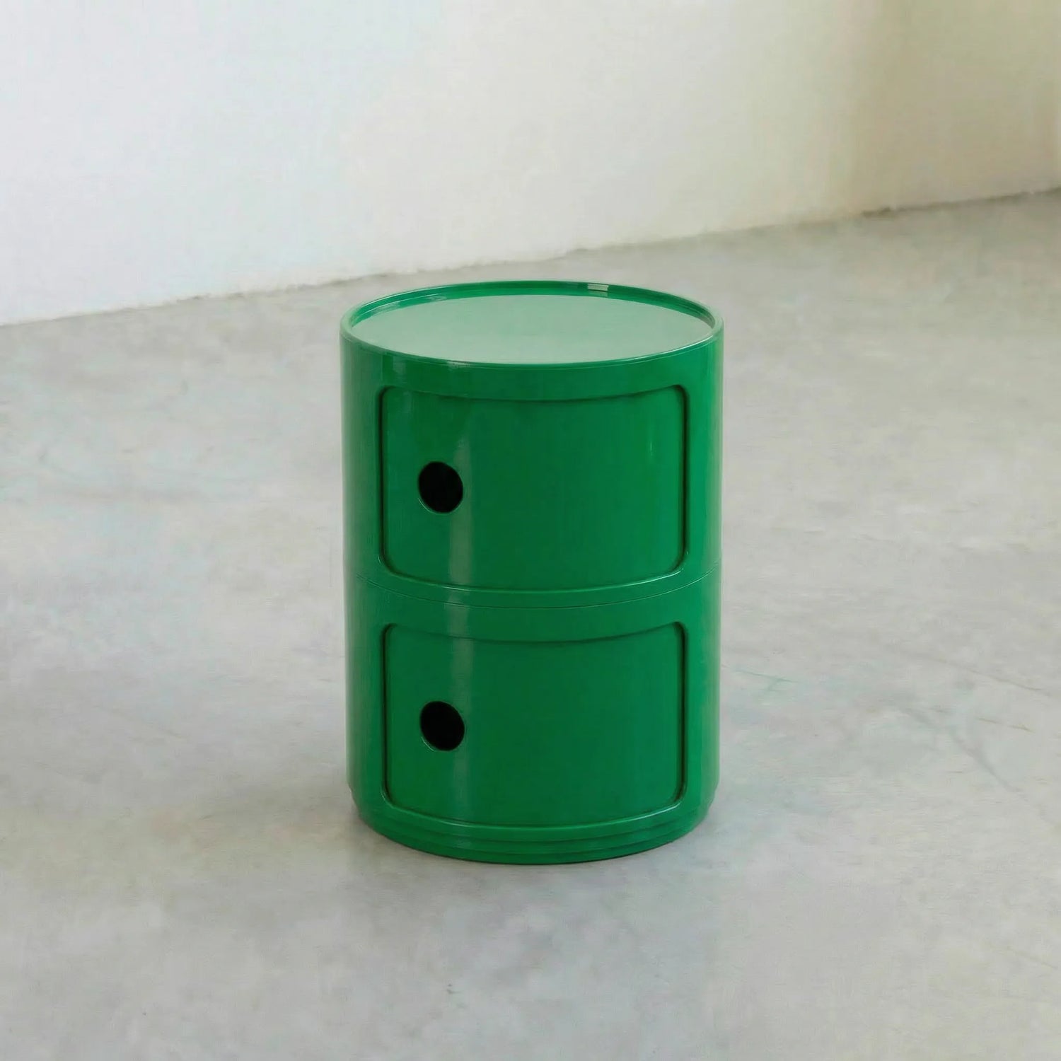 Green kartell componibili dupe storage unit with two drawers on a light gray surface.