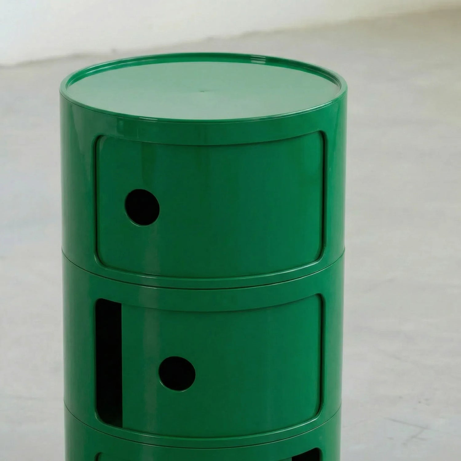 Green kartell componibili dupe storage unit with three drawers on a light gray surface.