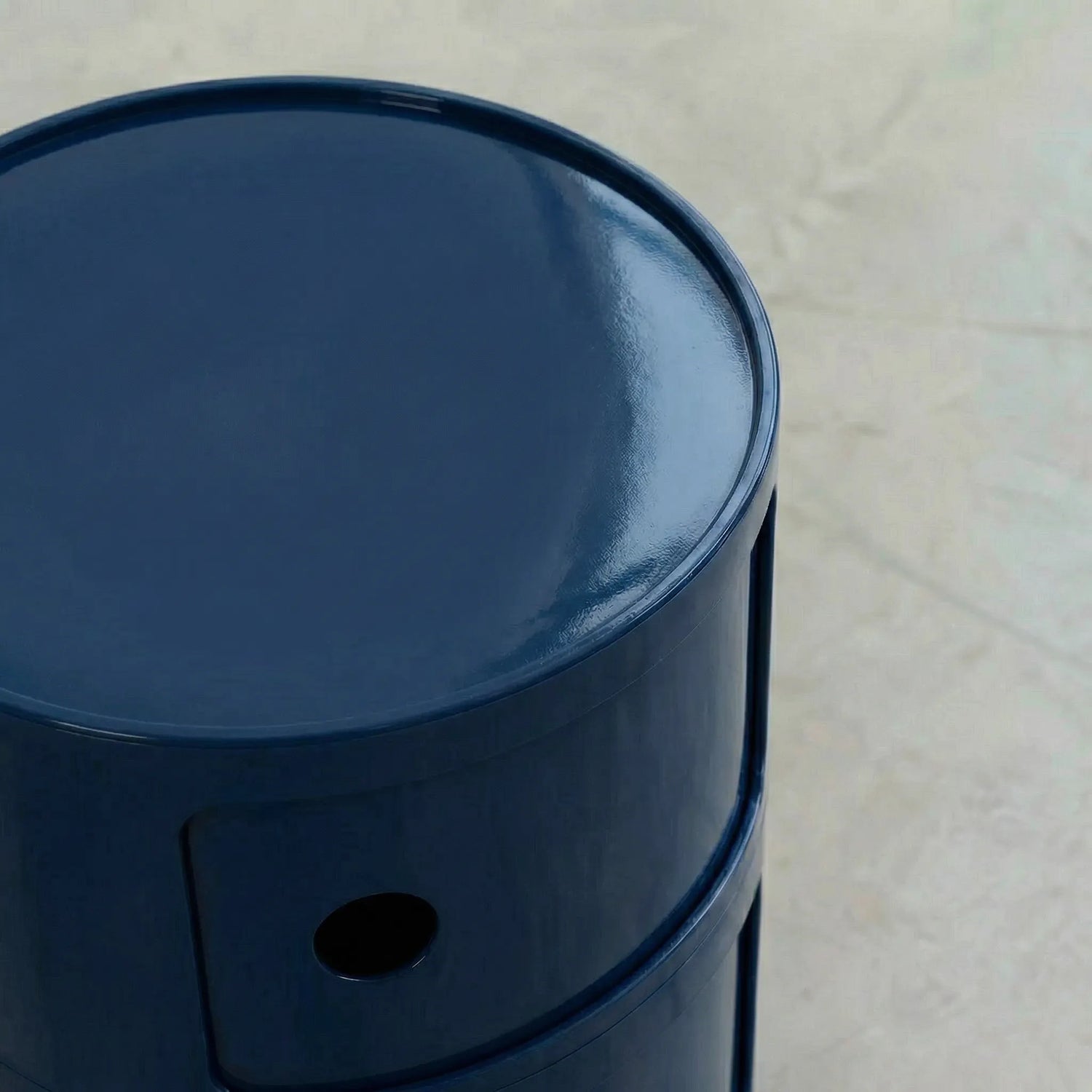 Close-up of the Navy Blue glossy round modular storage unit, Kartell Componibili dupe with three tiers in minimalist concrete studio