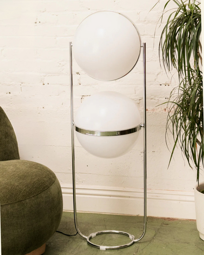 Modern floor globe double lamp with spherical white shades in a room setting.