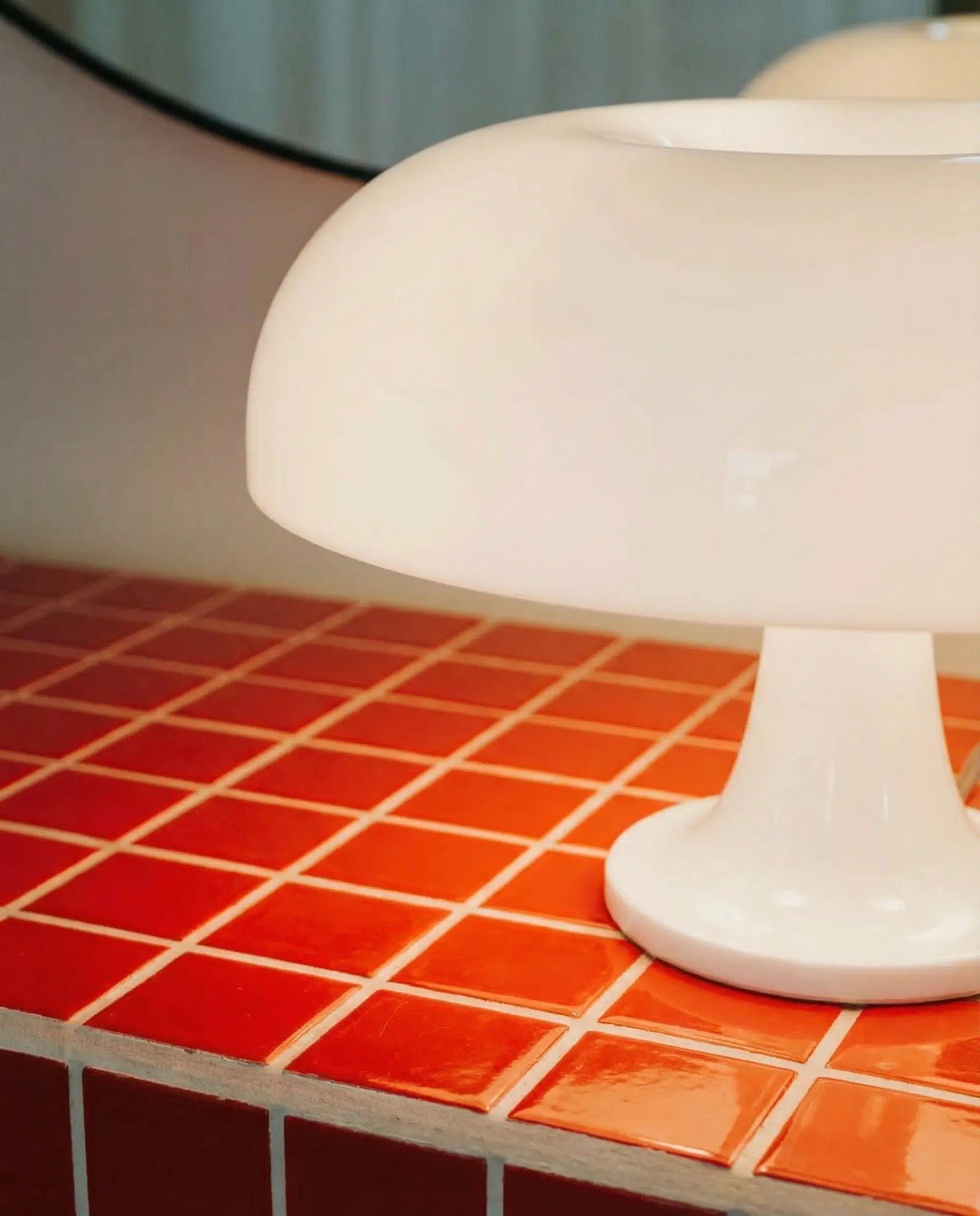 White nesso lamp dupe on a red tiled surface