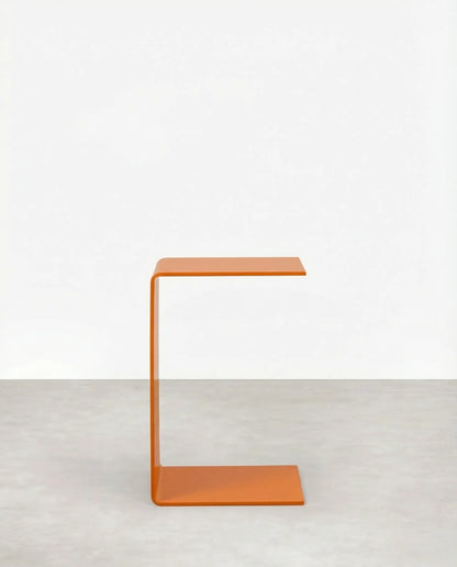 Orange c-shaped acrylic side table on a white background by vibehaus