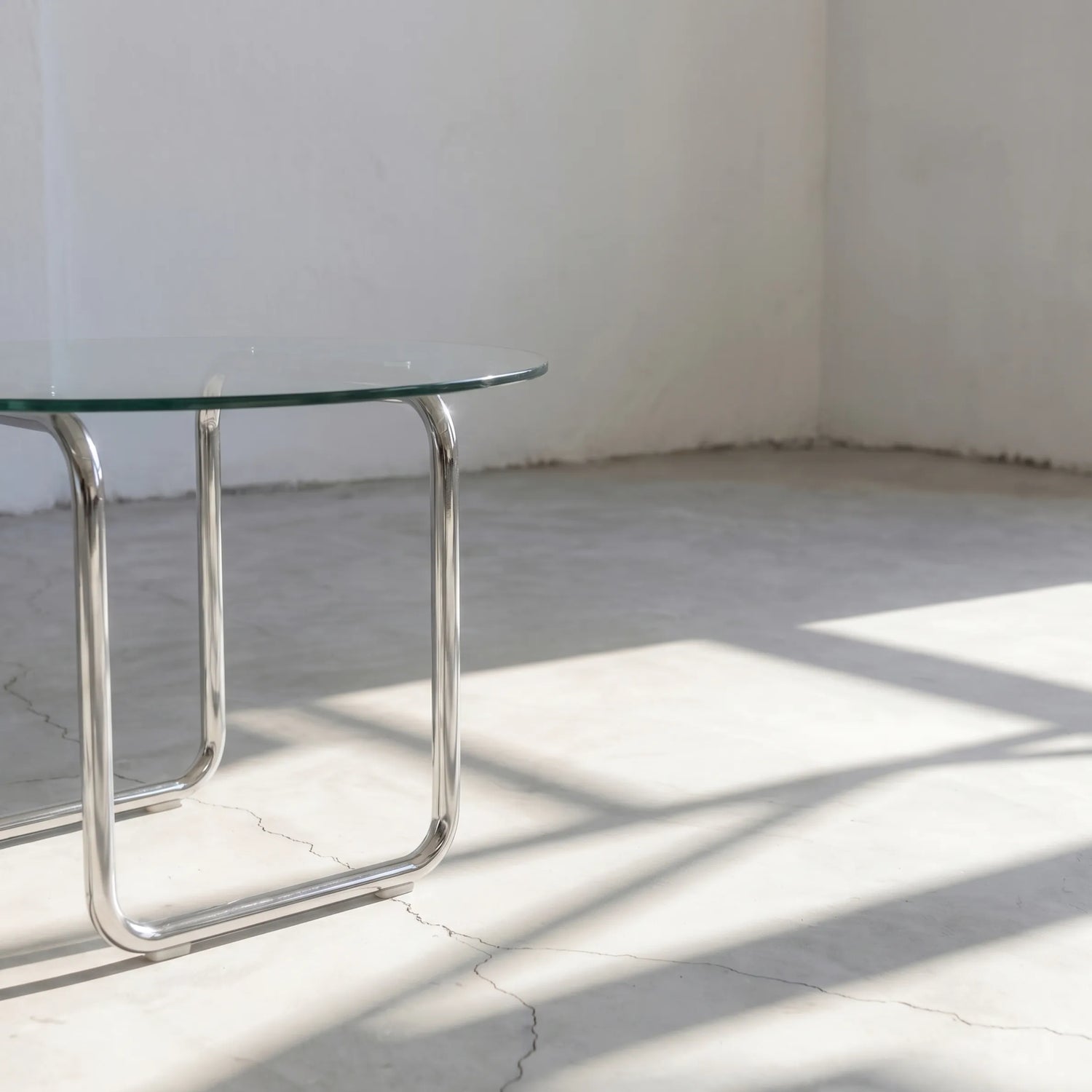 Orbit Round Glass Coffee Table, a round glass coffee table with a sculptural base for contemporary living rooms, styled view