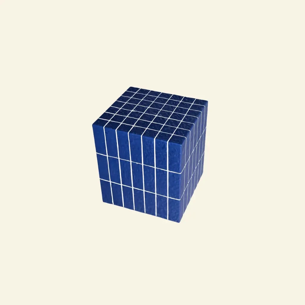 Blue ceramic-look cube side table with a glossy glazed finish on a soft beige background.
