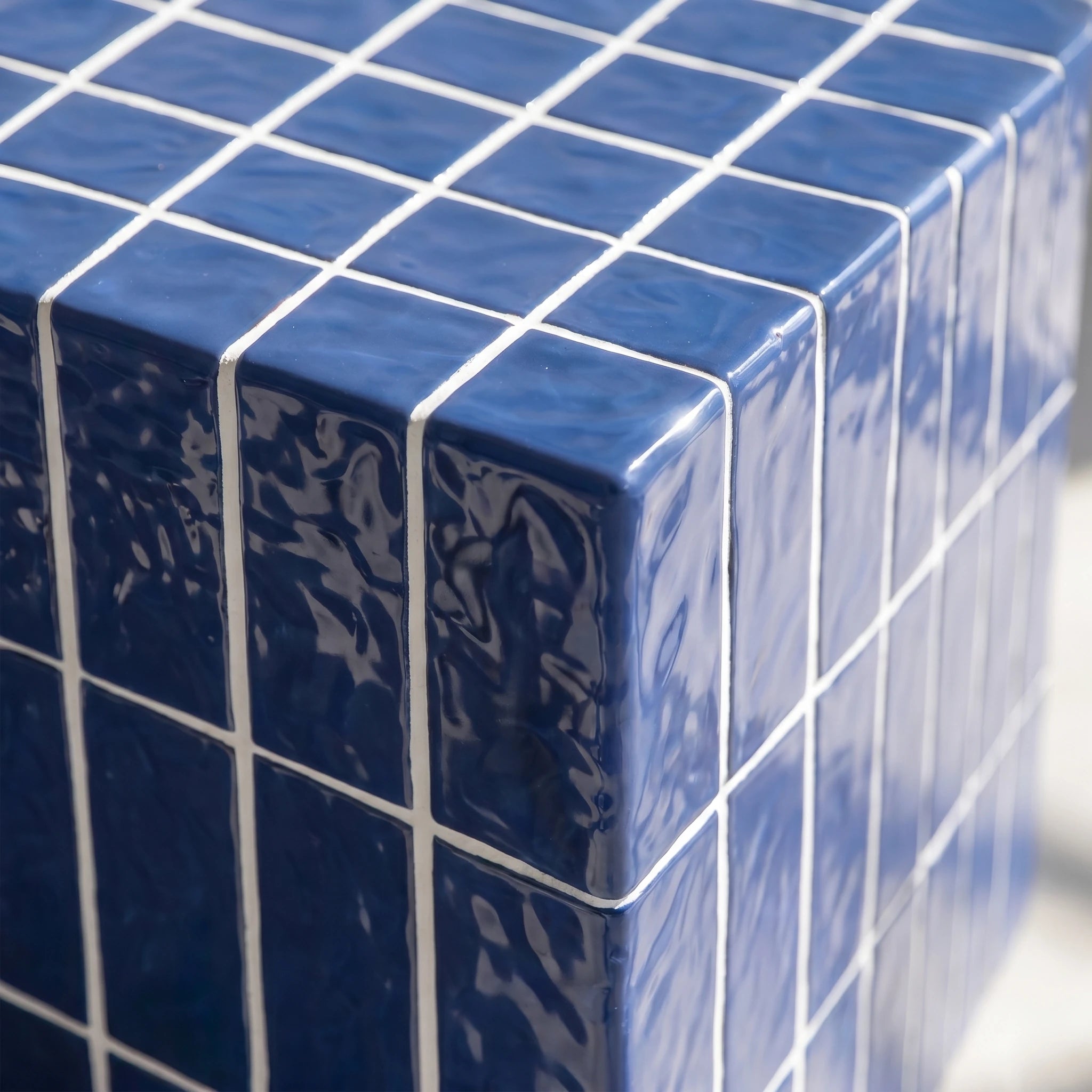 Detail shot of the sapphire blue cube side table with glossy finish and white grid lines.