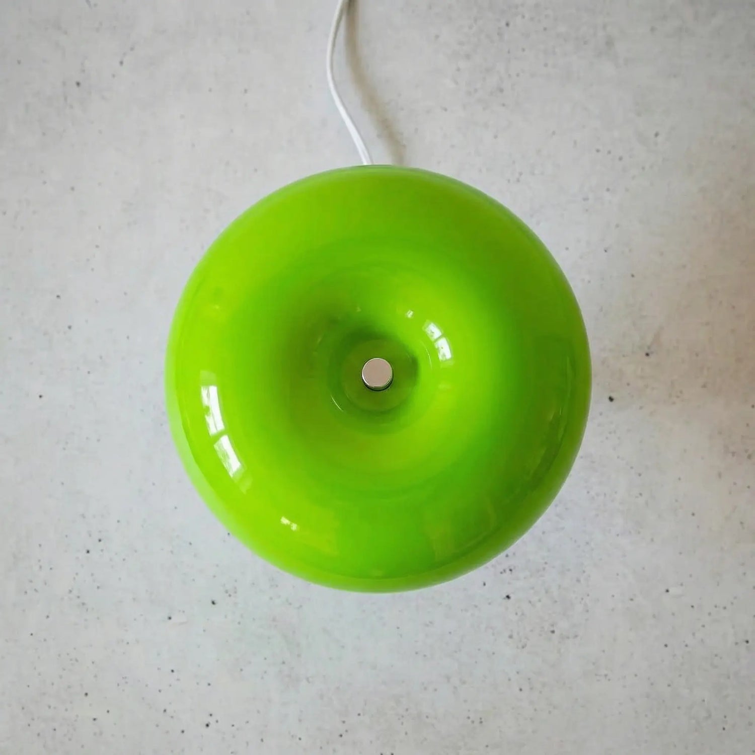 The Top of the Space age table lamp in green showing rounded glass sphere on a concrete floor.