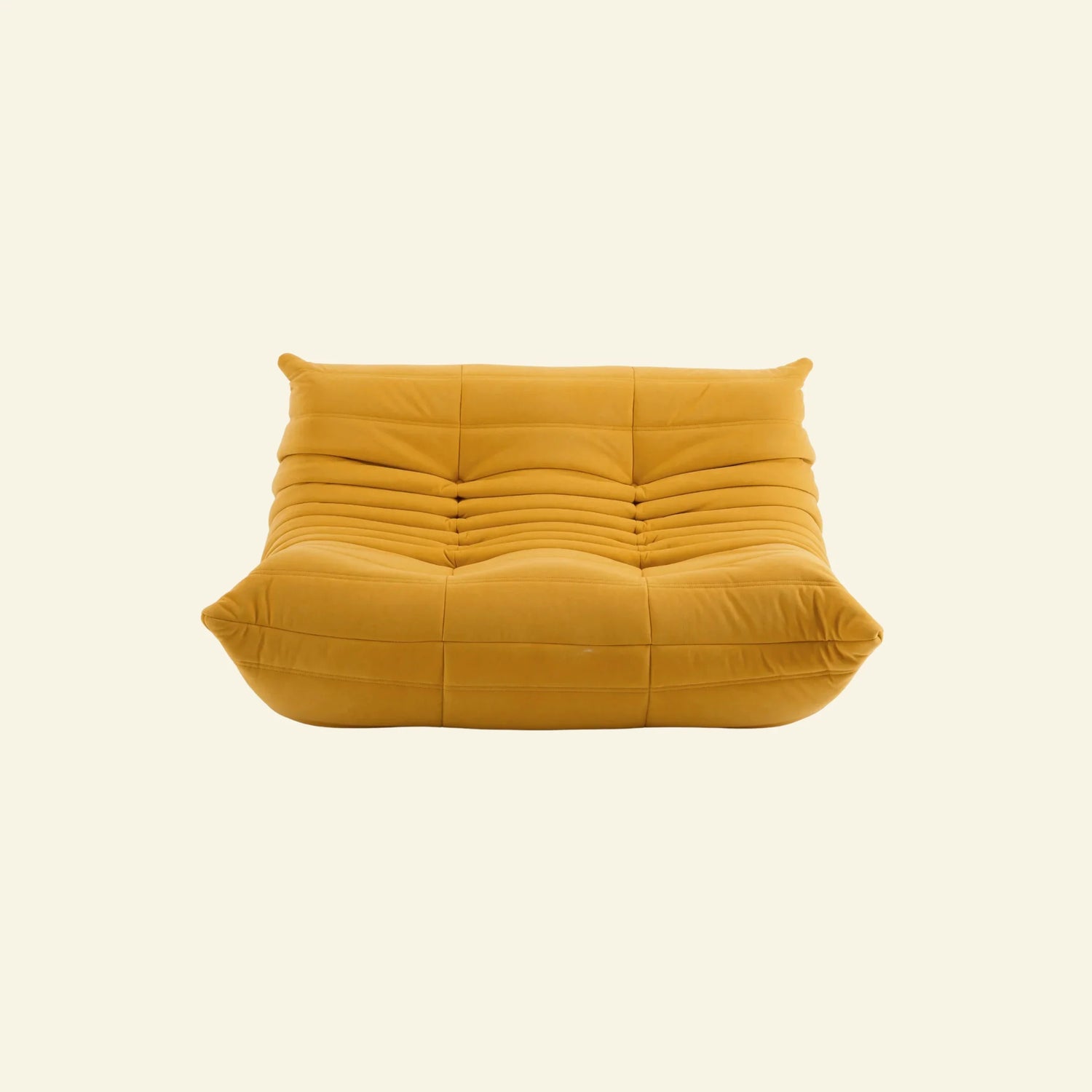togo sofa dupe in yellow velvet on a warm neutral studio background by vibehaus
