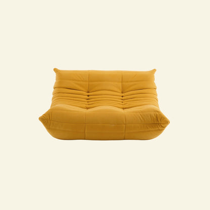 togo sofa dupe in yellow velvet on a warm neutral studio background by vibehaus