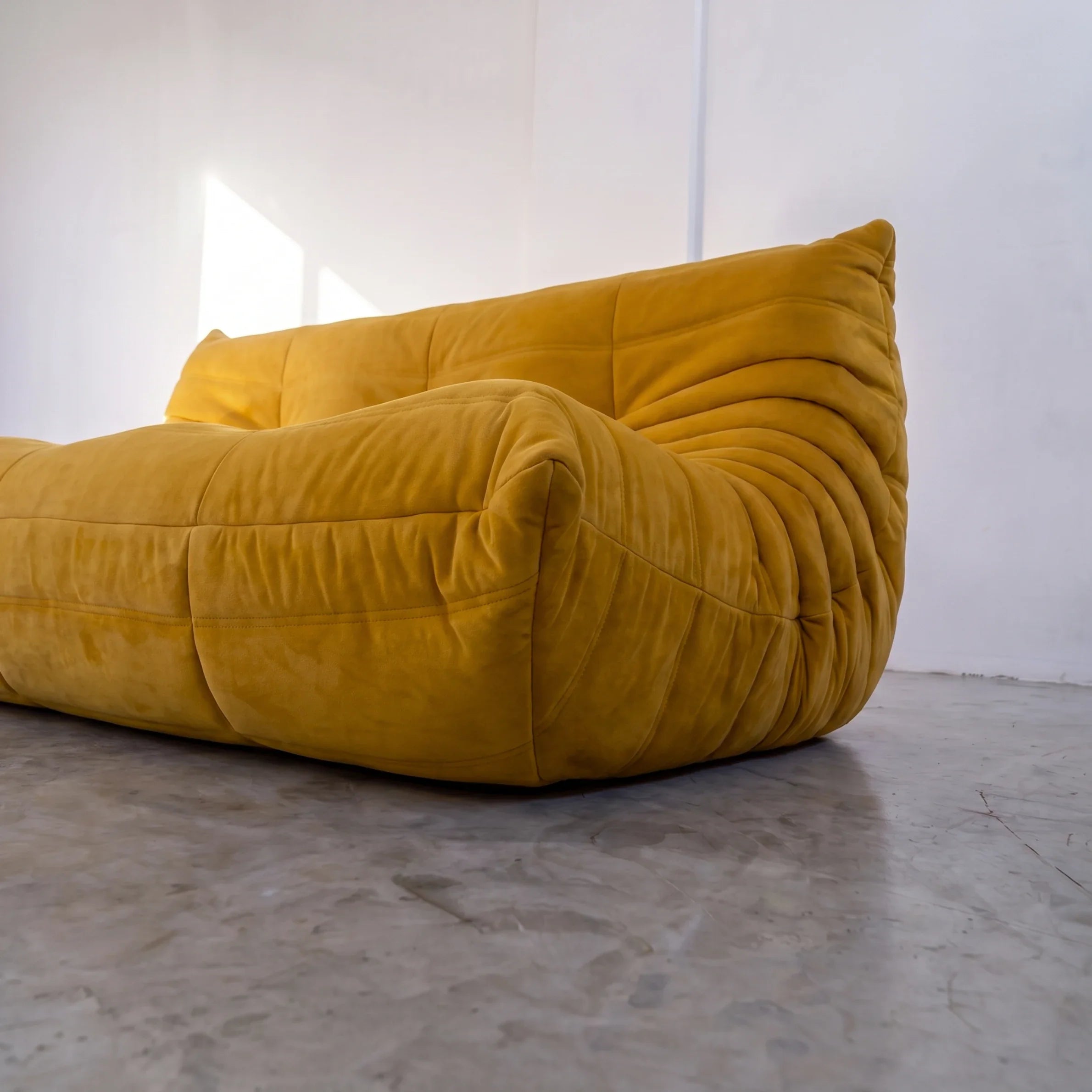 togo sofa dupe 3-seater close-up showing the yellow velvet upholstery and curved side detail by vibehaus