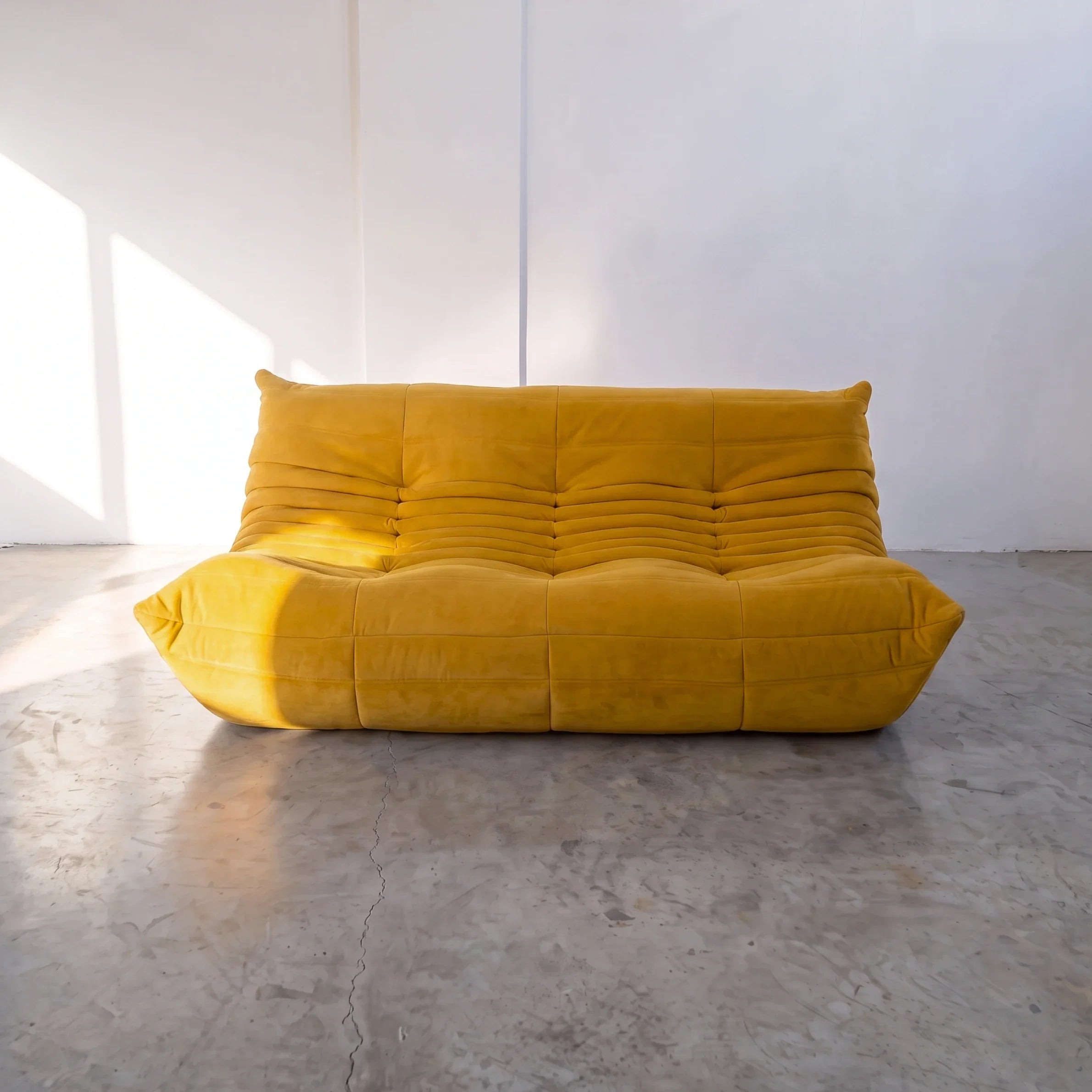 togo sofa dupe 3-seater in yellow velvet shown from the front in a sunlit studio by vibehaus