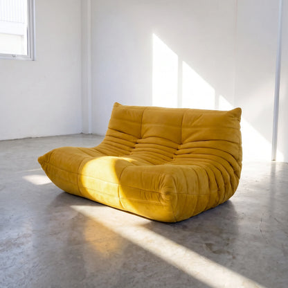 togo sofa dupe in yellow velvet shown from an angled front view in a sunlit studio by vibehaus