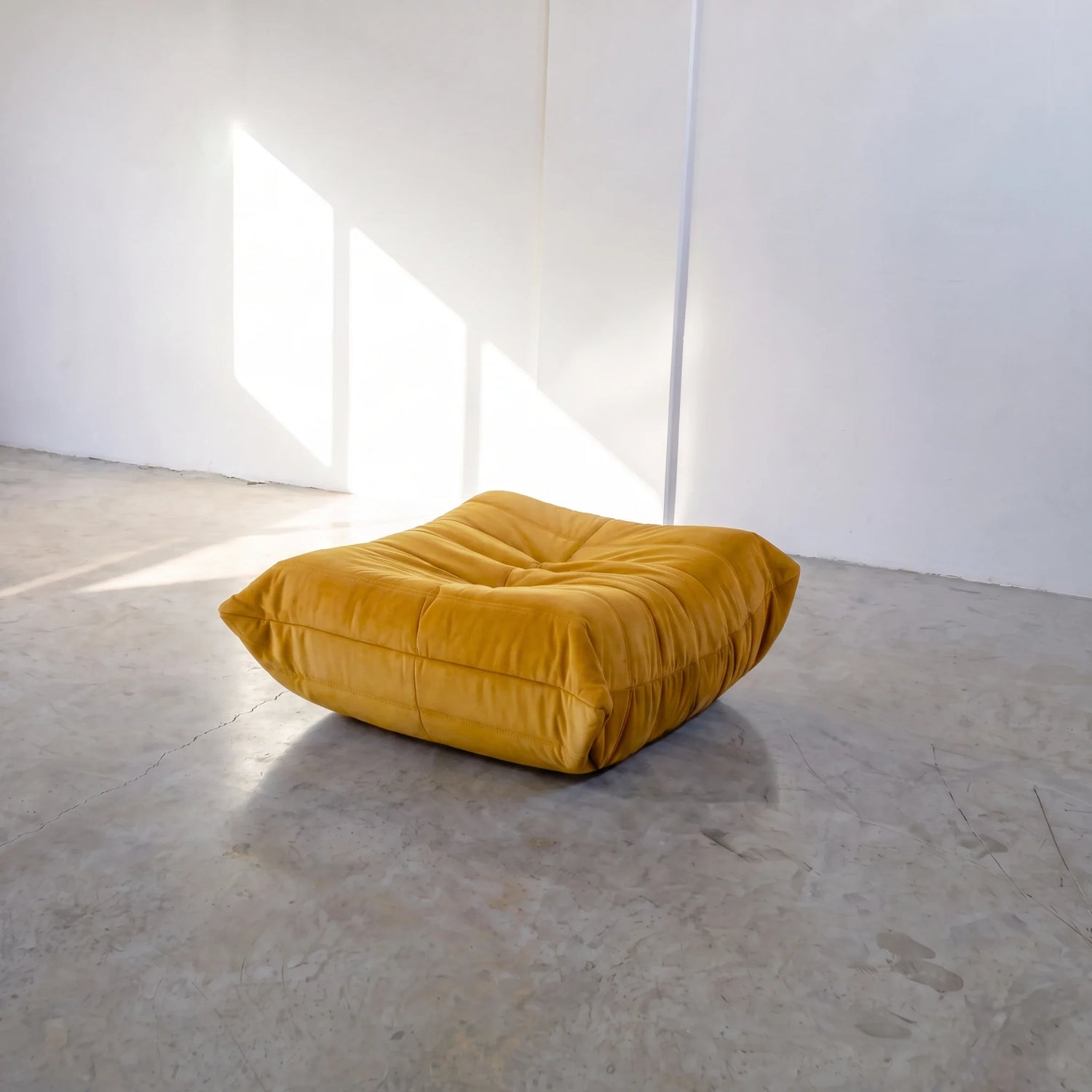togo sofa dupe ottoman in yellow velvet shown from an angled view in a sunlit studio by vibehaus